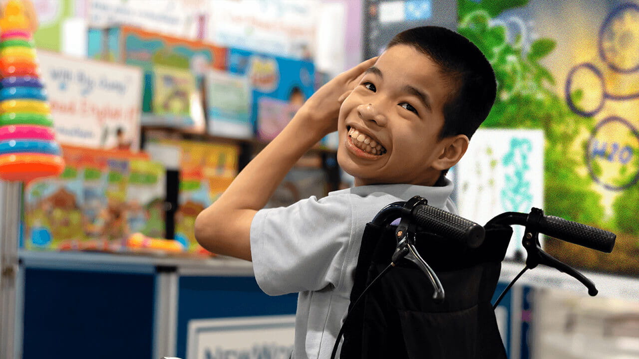 Smiling special needs student in a wheelchair